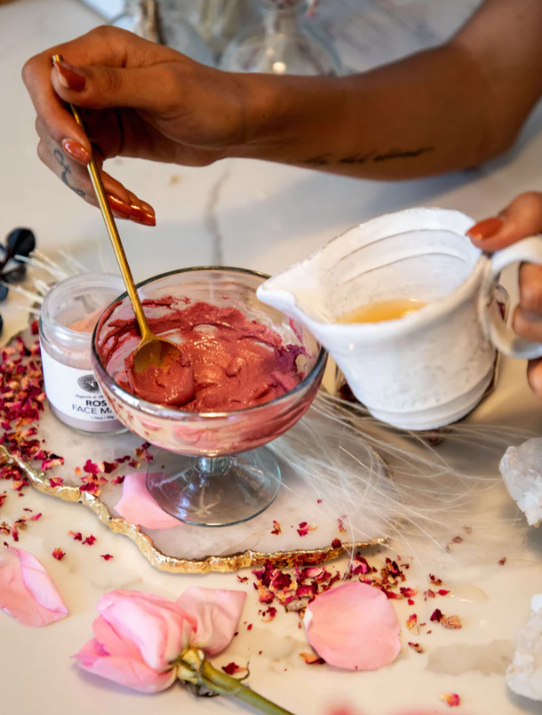 A girl mixing the Rose Face Mask on a glass