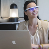 A girl with macbook wearing her Lighttherapy Glasses